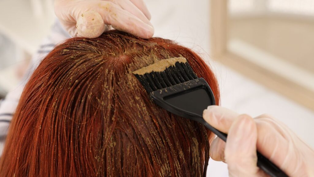 mulher tirando a tinta vermelha do cabelo