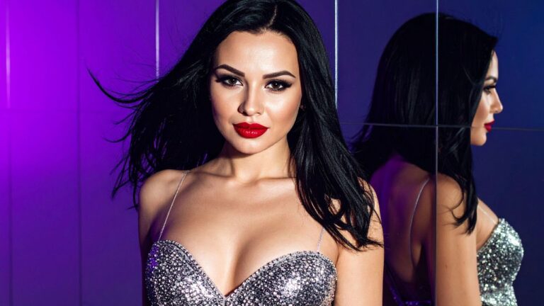 mulher com maquiagem de ano novo com batom vermelho vestindo vestido prateado