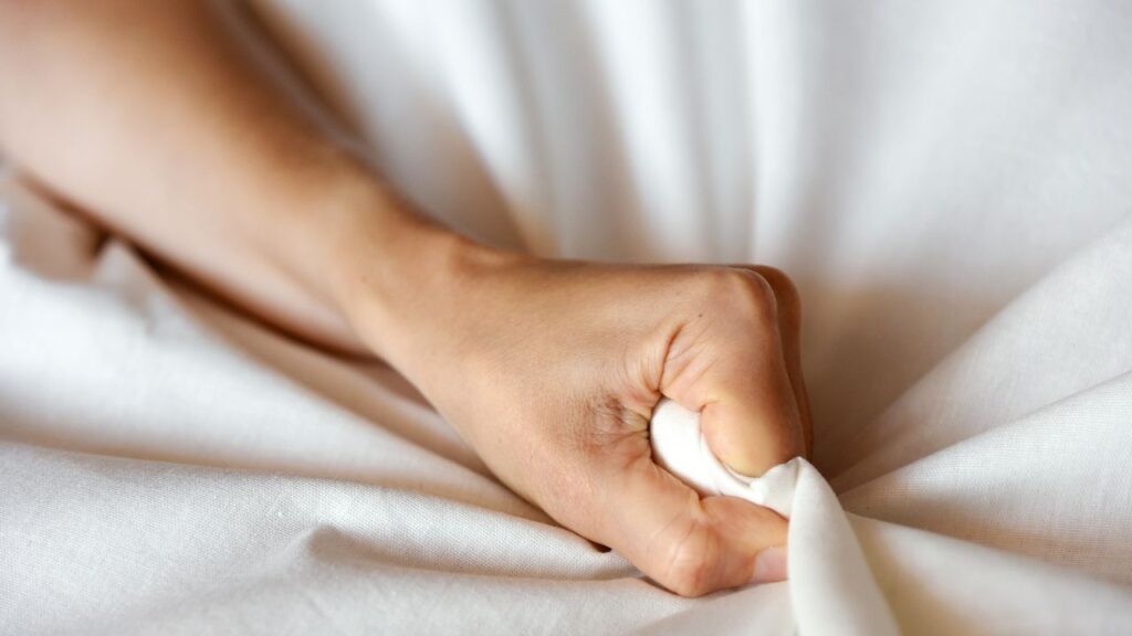 mãe agarrando lençol depois de ter um orgasmo noturno