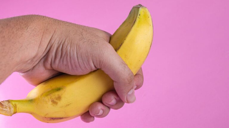 mão segurando banana simulando ereção