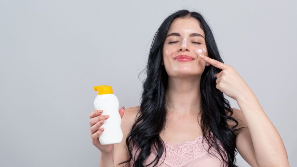 mulher passando de olhos fechados protetor solar no rosto