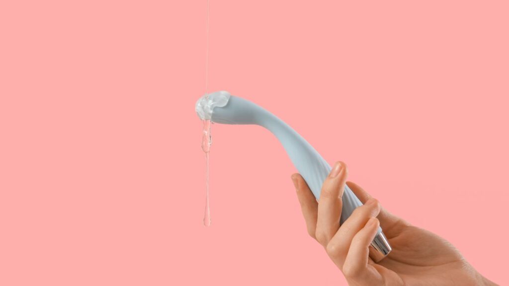 mulher segurando vibrador com lubrificante