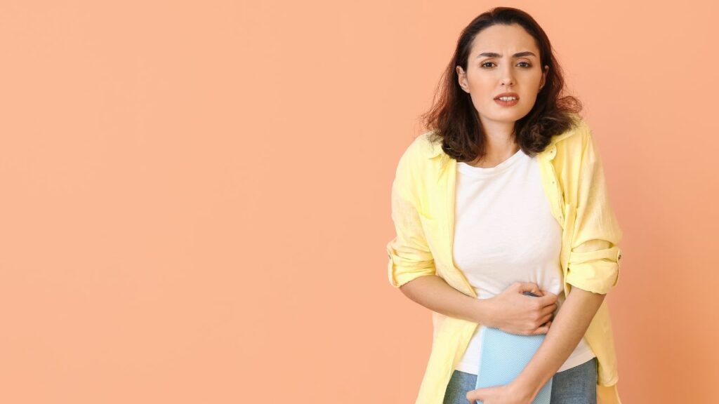 mulher com dor no baixo ventre fazendo compressa