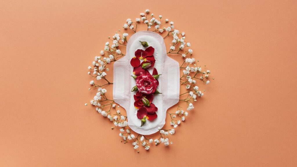 absorvente com flores representando menstruação em pedaços
