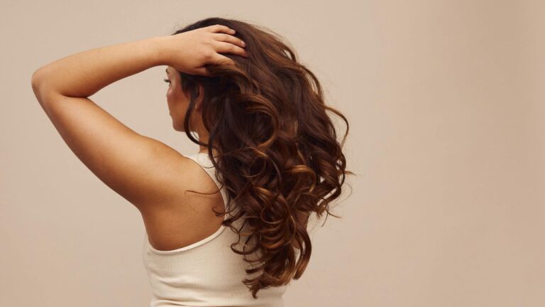 mulher de costas com as mãos no cabelo