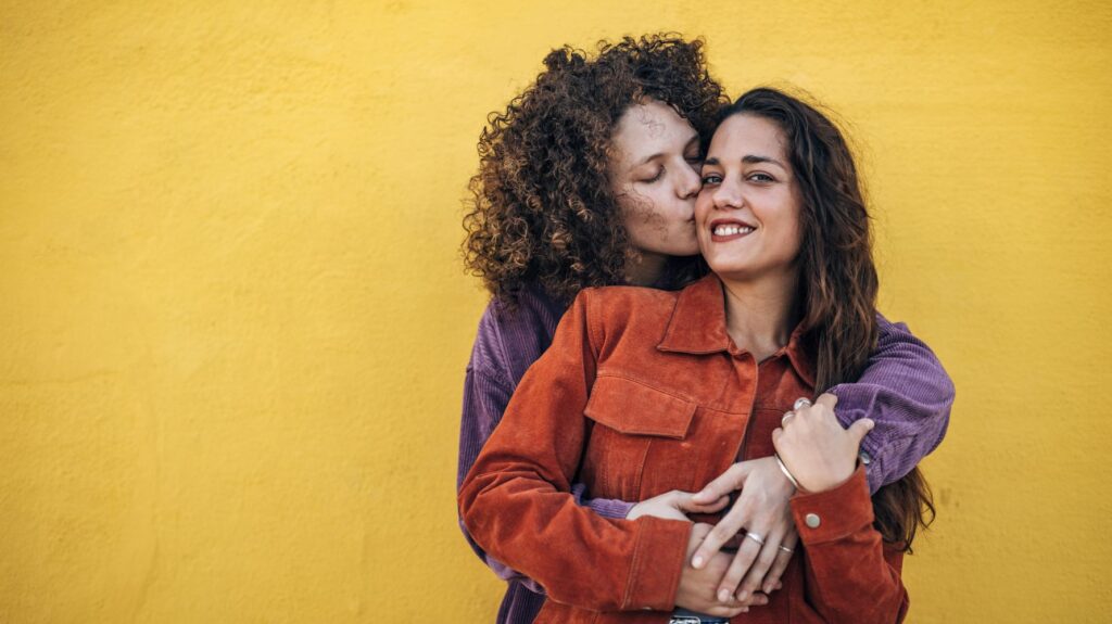mulheres se abraçando e beijando a bochecha uma da outra