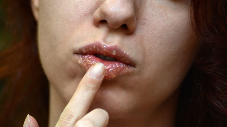 mulher aplicando esfoliante labial