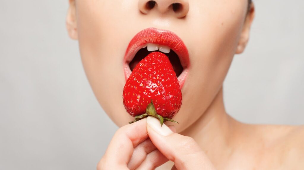 mulher comendo morango praticando sitofilia