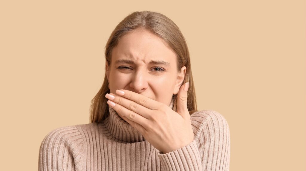 mulher com a mão no nariz sentindo cheiro forte de menstruação