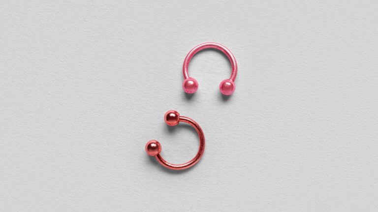 piercing rosa e vermelho em fundo cinza