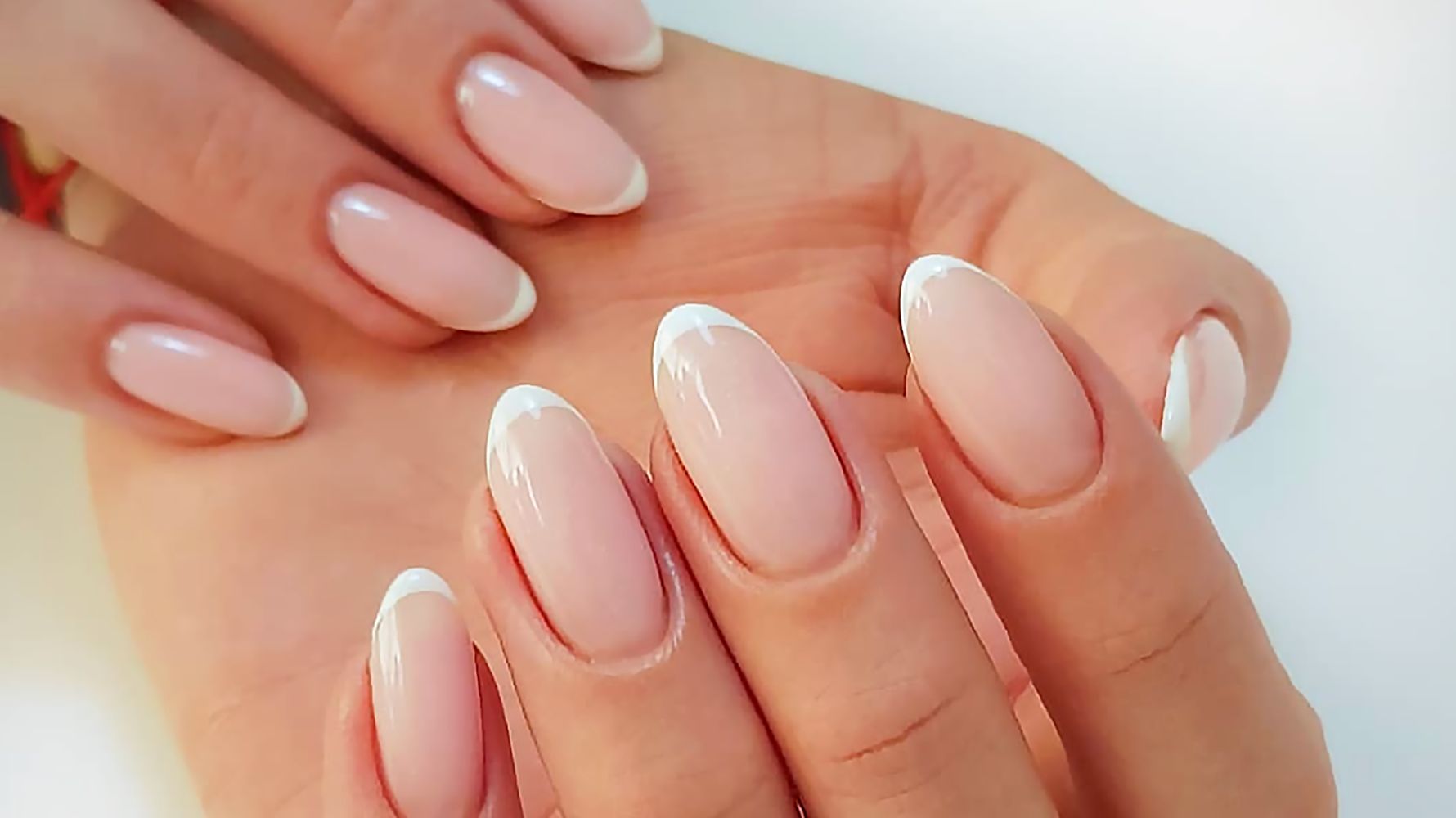 mãos com unhas amendoadas com francesinha
