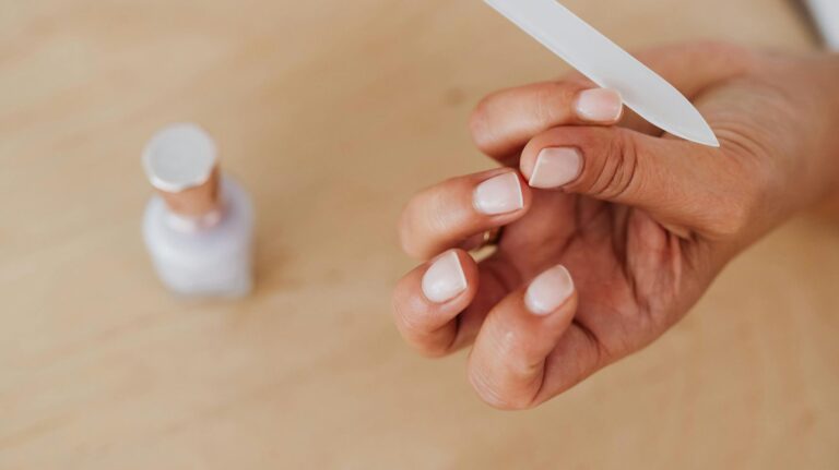 mulher lixando a unha após aprender como fazer as unhas em casa