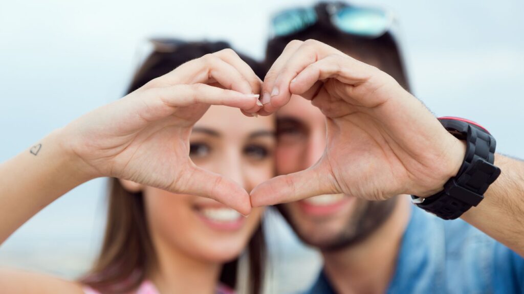 casal fazendo coração feliz