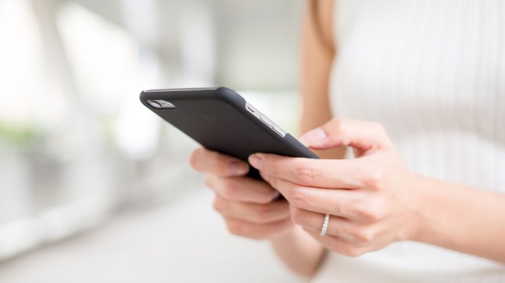 mulher usando celular para mandar mensagem para o dia dos namorados