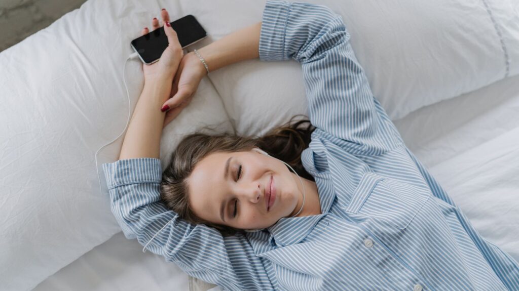 mulher feliz na cama com fone de ouvido