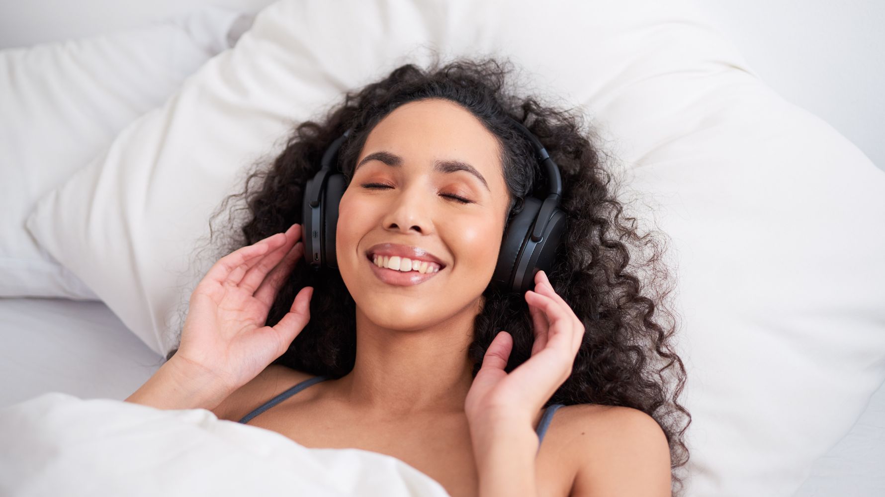 mulher com fone feliz na cama fazendo masturbação guiada