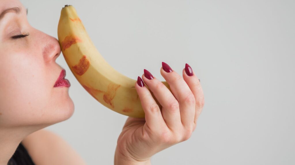 mulher segurando banana imitando sexo oral
