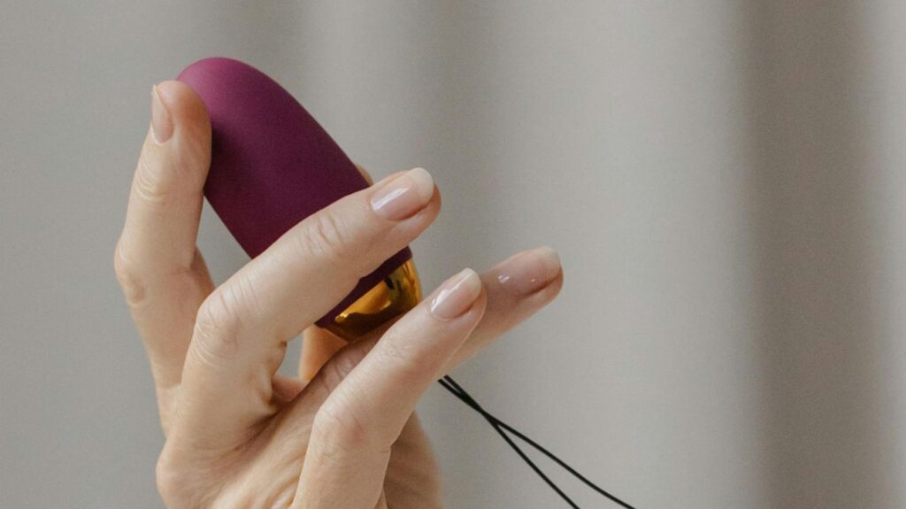 mulher segurando vibrador bullet roxo